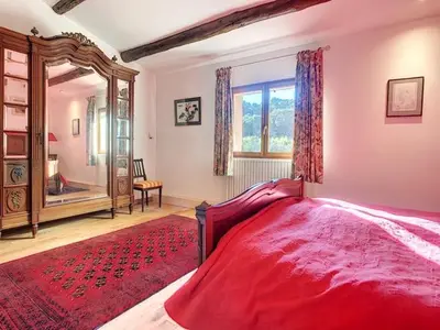 a bedroom with a large red bed and a mirror at LesArnauds in Aix-en-Provence