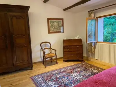 a bedroom with a dresser and a chair and a bed at LesArnauds in Aix-en-Provence