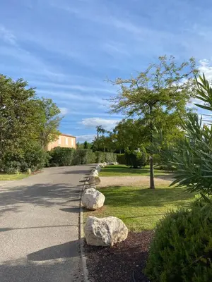 a road with rocks and a tree and a building at Les Demeures du Ventoux in Aubignan