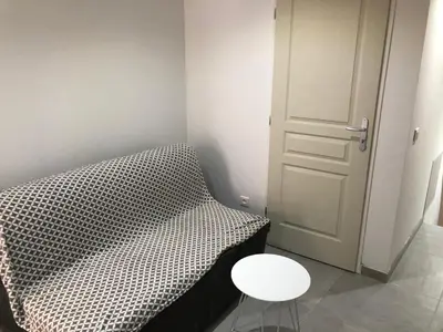 a bedroom with a bed and a table and a door at Les Olives Wifi Netflix Appart-hotel-Provence in La Fare-les-Oliviers