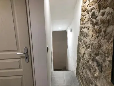 a hallway with a door and a stone wall at Les Olives Wifi Netflix Appart-hotel-Provence in La Fare-les-Oliviers