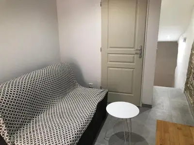 a room with a bed and a table next to a door at Les Olives Wifi Netflix Appart-hotel-Provence in La Fare-les-Oliviers