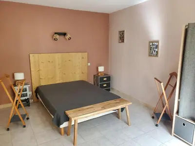a bedroom with a bed and a table and chairs at Gîte Les Murmures du Ventoux in Mormoiron