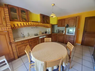 a kitchen with a table and chairs and yellow walls at Gîte Les Murmures du Ventoux in Mormoiron