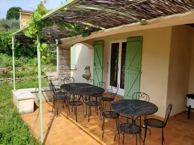 a patio with tables and chairs under a pergola at Gîte Les Murmures du Ventoux in Mormoiron