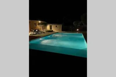 a swimming pool lit up at night at La Rose Des Vents in Modène