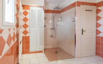 a bathroom with a shower with a glass door at La Rose Des Vents in Modène