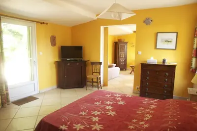 a bedroom with a bed and a television in it at Le petit Bacalan in Mormoiron