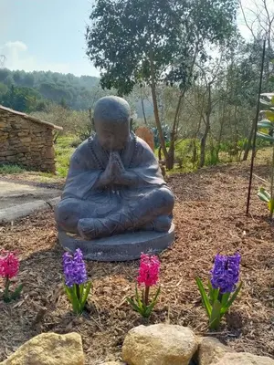 a statue of a woman sitting on the ground with flowers at Gîte du domaine de l'Arbre de Vie in Saint-Chamas
