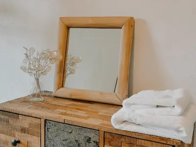 a mirror on top of a wooden dresser with towels at La Source in Oppedette