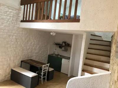 a room with a staircase with a desk and a kitchen at Studio 57 à Saignon in Saignon