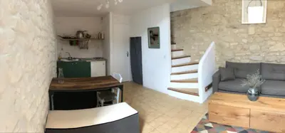 a living room with a couch and a stair case at Studio 57 à Saignon in Saignon