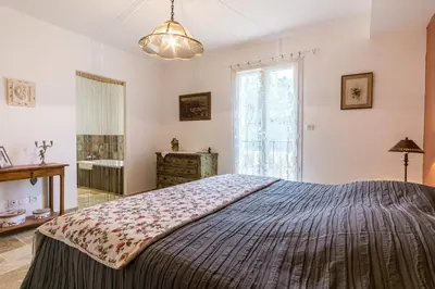 a bedroom with a large bed and a window at Stunning house on the edge of the Luberon in Cheval-Blanc
