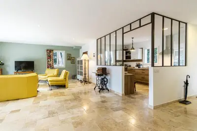 a living room with a yellow couch and a kitchen at Stunning house on the edge of the Luberon in Cheval-Blanc