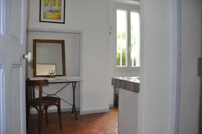 a bathroom with a vanity with a mirror and a table at La Figuiere Fontaine de Vaucluse in Fontaine-de-Vaucluse