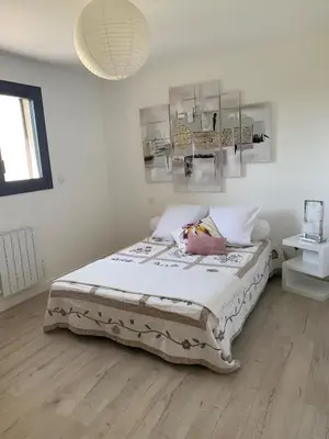 a bedroom with a bed with white walls and wooden floors at Villa moderne en Provence avec piscine in Carpentras