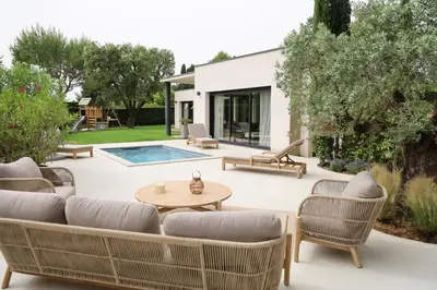 a patio with chairs and a table and a pool at Villa moderne en Provence avec piscine in Carpentras