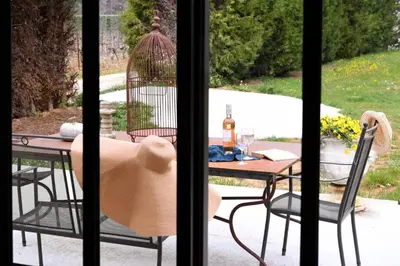 a table and chairs and a bird cage on a patio at Le Galinié Chic'Art. Un bel Atelier avec Piscine in Carpentras