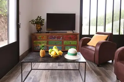 a living room with a table with a bowl of fruit at Le Galinié Chic'Art. Un bel Atelier avec Piscine in Carpentras