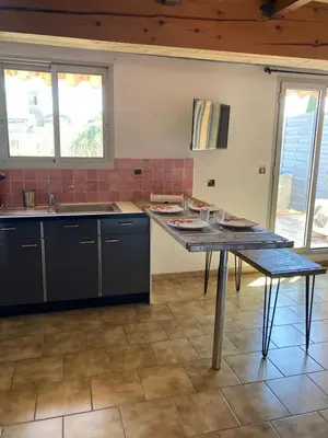 a kitchen with a table and a counter top at Grande terrasse CLIM parking privé SMART TV, local velos in Entraigues-sur-la-Sorgue