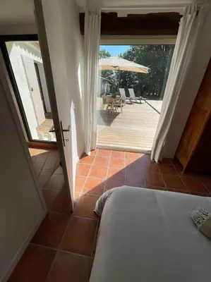 a bedroom with a bed and a patio with an umbrella at Mas de la Pivoine in Le Puy-Sainte-Réparade