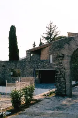 a large stone building with a large garage at Les Milles Roches in Gordes