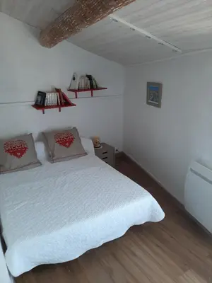 a bedroom with a white bed with two pillows at Gite au cœur du Luberon in Goult