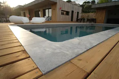 a swimming pool with two white chairs and a house at La Possibilité d'une Ile in Apt