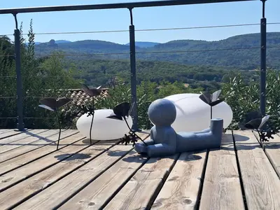 a metal doll sitting on a wooden table with a view at La Possibilité d'une Ile in Apt