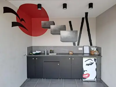 a kitchen with a sink and a red face on the wall at La Possibilité d'une Ile in Apt
