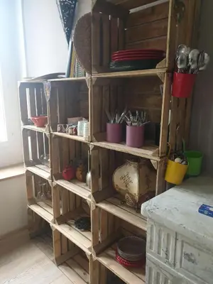 a wooden shelving unit with pots and pans at Charmant appartement cœur village provençal in Lambesc