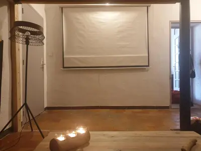 a projector screen in a room with candles on the floor at Charmant appartement cœur village provençal in Lambesc