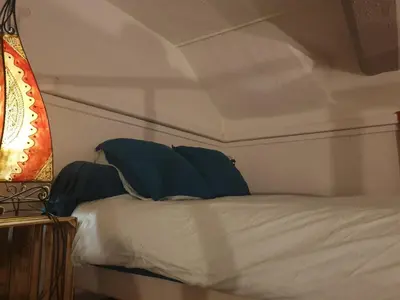 a bed with blue pillows on top of it at Charmant appartement cœur village provençal in Lambesc