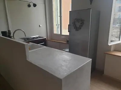 a kitchen with a counter and a refrigerator at Charmant appartement cœur village provençal in Lambesc