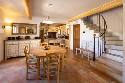a kitchen and dining room with a wooden table and chairs at La Bastide des Milles in Apt
