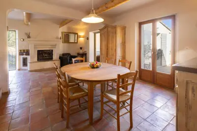 a kitchen and dining room with a wooden table and chairs at La Bastide des Milles in Apt