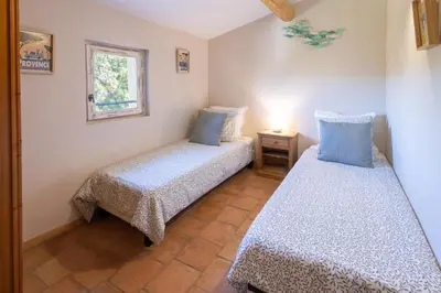 a bedroom with two beds and a window at La Bastide des Milles in Apt