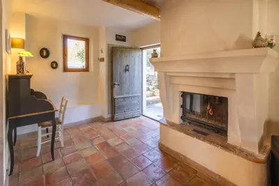 a living room with a fireplace and a piano at La Bastide des Milles in Apt