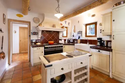 a kitchen with white cabinets and a stove top oven at La Bastide des Milles in Apt