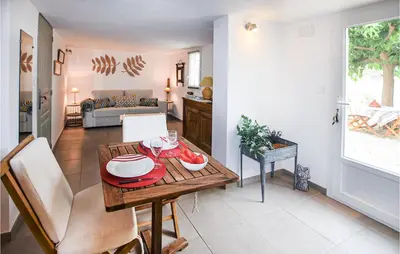 a kitchen and living room with a table and chairs at Nice Apartment In Caumont-Sur-Durance in Caumont-sur-Durance