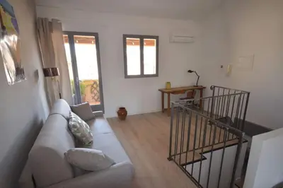 a living room with a couch and a staircase at LE DIX Duplex historical center balcony with view and air conditioning in Aix-en-Provence
