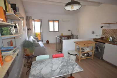 a living room with a table and a kitchen at LE DIX Duplex historical center balcony with view and air conditioning in Aix-en-Provence
