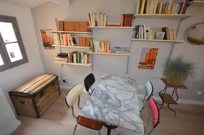 a room with a table and chairs and bookshelves at LE DIX Duplex historical center balcony with view and air conditioning in Aix-en-Provence