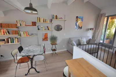 a living room with a table and chairs and a couch at LE DIX Duplex historical center balcony with view and air conditioning in Aix-en-Provence