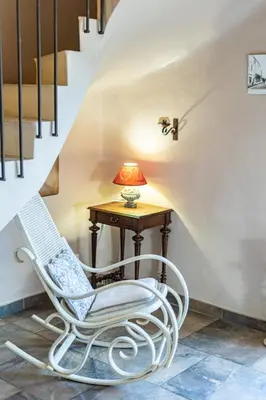 a white rocking chair next to a table with a lamp at Stunning property between Alpilles and Luberon in Cavaillon