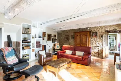 a living room with leather furniture and a stone wall at Stunning property between Alpilles and Luberon in Cavaillon
