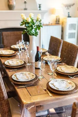 a wooden table with plates and glasses and a vase with flowers at Stunning property between Alpilles and Luberon in Cavaillon