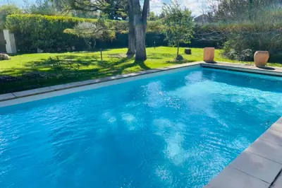a swimming pool with blue water in a yard at Stunning property between Alpilles and Luberon in Cavaillon