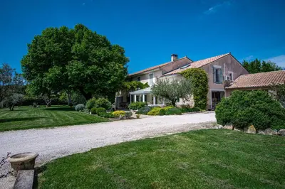 a house with a gravel driveway in front of a yard at Stunning property between Alpilles and Luberon in Cavaillon