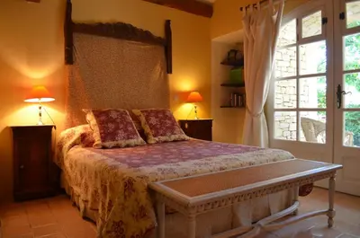a bedroom with a bed and a large window at Le Mas Perréal in Saint-Saturnin-les-Apt
